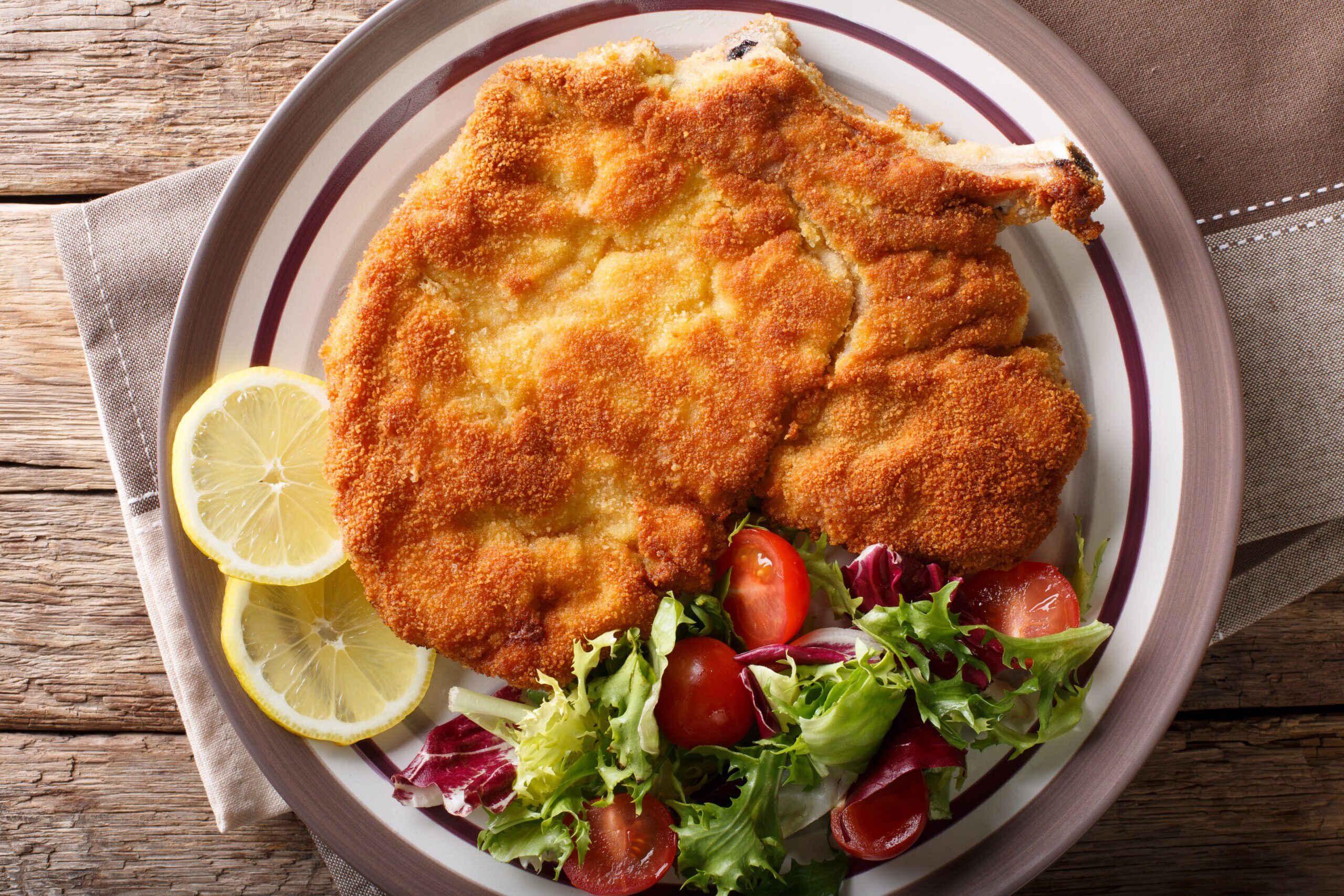 veal-milanese-cotoletta-alla-milanese-with-lemon-and-fresh-vegetable-salad-close-up-horizontal-top-view-2